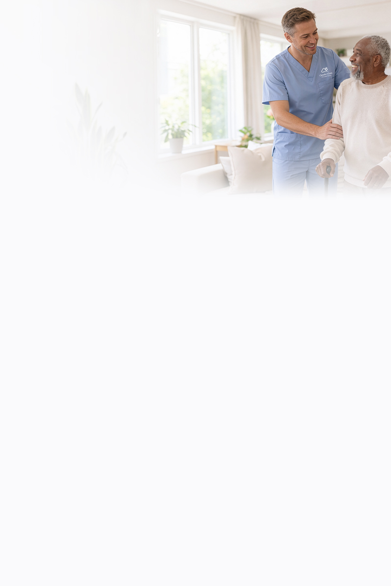 A Clouds of Care caregiver in blue scrubs walks alongside an elderly man with a cane, offering steady support and encouragement in a bright home setting